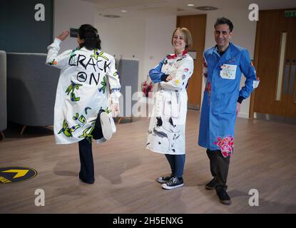 (left to right) Rosalind Wyatt, cancer patient Laura Nuttall and Professor Chris Jones wearing three lab coats which have been made into a 'wearable work of art', and are on display at the Institute of Cancer Research in Sutton, south west London. British textile artist Rosalind Wyatt has transformed three lab coats with hand-stitched quotes, letters and illustrations from children and adults with rare and hard to treat cancers, raising awareness of 'cancers of unmet need'. Picture date: Tuesday November 9, 2021. Stock Photo