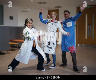 (left to right) Rosalind Wyatt, cancer patient Laura Nuttall and Professor Chris Jones wearing three lab coats which have been made into a 'wearable work of art', and are on display at the Institute of Cancer Research in Sutton, south west London. British textile artist Rosalind Wyatt has transformed three lab coats with hand-stitched quotes, letters and illustrations from children and adults with rare and hard to treat cancers, raising awareness of 'cancers of unmet need'. Picture date: Tuesday November 9, 2021. Stock Photo