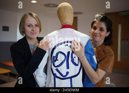 A quote from cancer patient Laura Nuttall (left) has been hand-stitched onto the back of one of three lab coats which have been made into a 'wearable work of art' by Rosalind Wyatt (right), which are on display at the Institute of Cancer Research in Sutton, south west London. British textile artist Rosalind Wyatt has transformed three lab coats with hand-stitched quotes, letters and illustrations from children and adults with rare and hard to treat cancers, raising awareness of 'cancers of unmet need'. Picture date: Tuesday November 9, 2021. Stock Photo