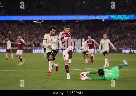 Lukasz Fabianski of West Ham United gathers up the ball as Mohamed Salah of Liverpool and Aaron Cresswell of West Ham United close in - West Ham United v Liverpool, Premier League, London Stadium, London, UK - 7th November 2021  Editorial Use Only - DataCo restrictions apply Stock Photo