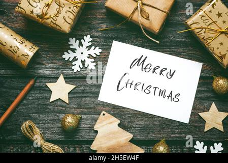 Merry Christmas. Top view of Christmas ornaments and christmas greeting card on wooden table. Christmas concept background Stock Photo