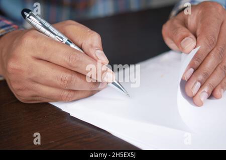 man hand in fountain pen writing or signature on paper . Stock Photo
