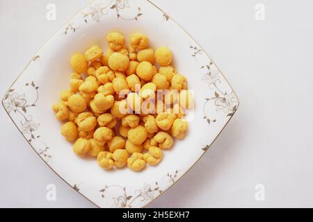 puffed corn rings chips in black bowl on white background Stock Photo
