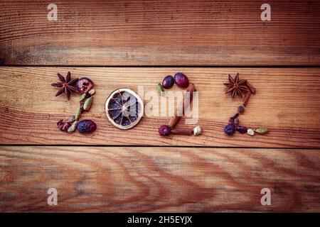 2022 written with Christmas spices and dried fruits on wooden background, new year greeting card