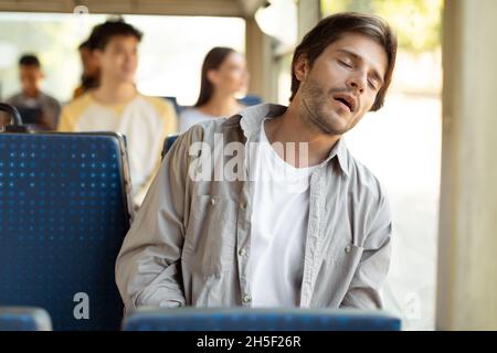 Portrait of tired guy sleeping in bus Stock Photo