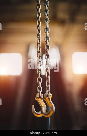 Two iron hooks hang on chains. Stock Photo