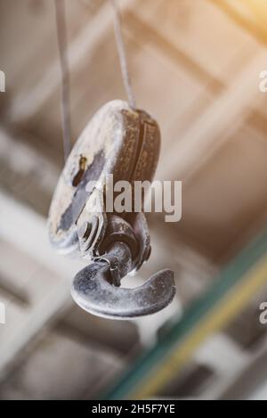Massive metal crane hook hanging on a cable. Stock Photo
