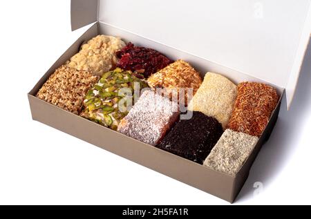 Turkish delight. Set of assorted Turkish delights with various flavors cream-filled in gift cardboard box. Lokum rolls covered nuts and sugar powder. Stock Photo