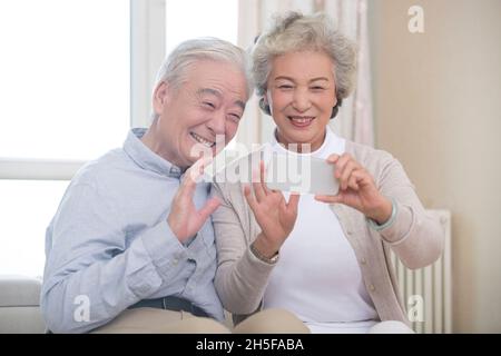 Happy elderly couple having video call on their cell phone Stock Photo
