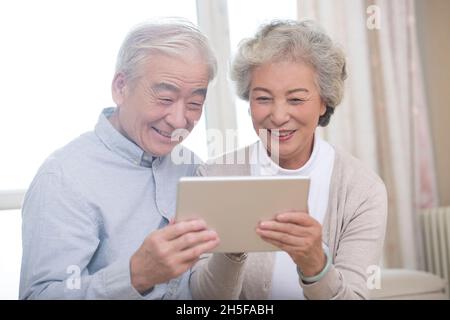 Happy elderly couples using tablets Stock Photo
