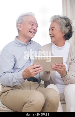 Happy elderly couples using tablets Stock Photo
