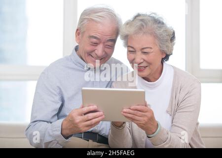 Happy elderly couples using tablets Stock Photo