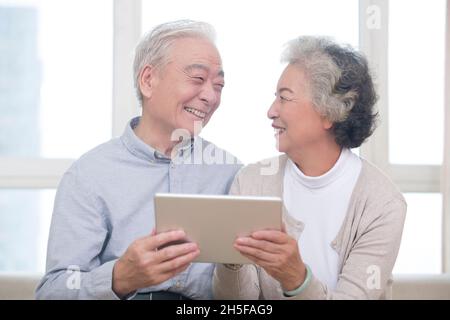 Happy elderly couples using tablets Stock Photo