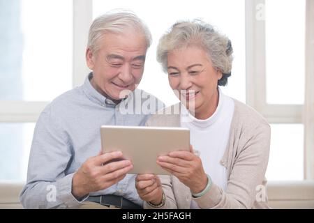 Happy elderly couples using a tablet computer Stock Photo