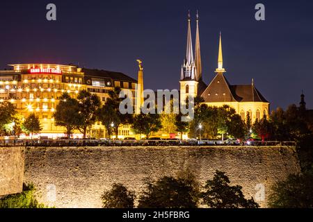 Notre Dame church  and Monument of Remembrance in Luxembourg city at night overlooking the old wall Stock Photo