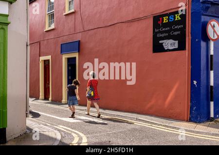 Street scene on a summer morning in Kinsale, woman in red dress and young girl dancing, County Cork, Ireland Stock Photo