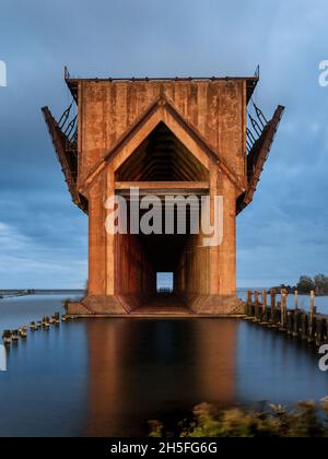 Vertical shot of the Lower Harbor Ore Dock surrounded by the sea with long exposure in Michigan Stock Photo