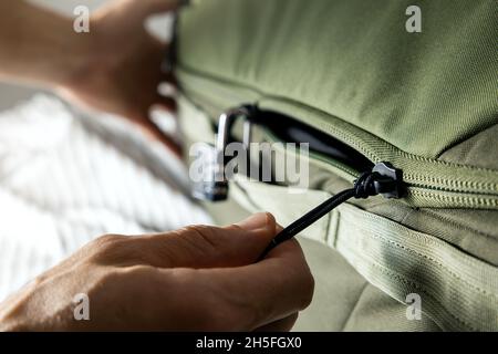man closing travel suitcase zip on the bed. closeup Stock Photo