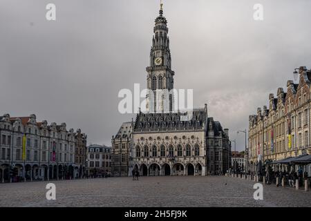 Arras, France - November 4, 2021: Town square of Arras, France. UNESCO World Heritage Site, the Belfry of Arras, against a dark grey sky Stock Photo