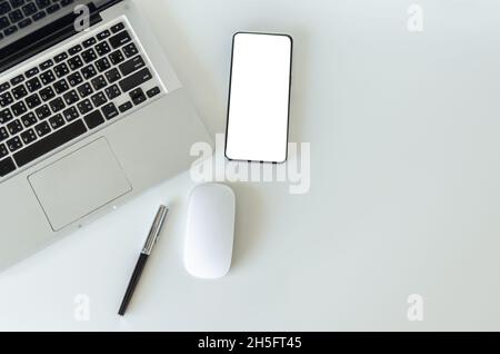 Top view mock up smartphone with mouse computer latop and pen.Copy space flatlay. Stock Photo