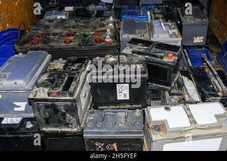 Pallet with used car batteries waiting to be recycled in an environmentally harmful scrap yard Stock Photo