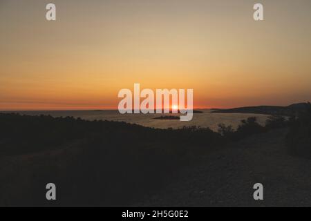 Golden, summer sky during amazing sunset over Kornati islands observed from the hill above small tourist town of Rogoznica, Croatia Stock Photo