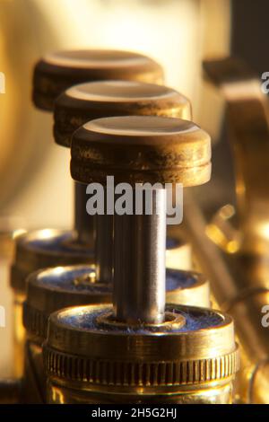 Trumpet valves brass in a line with differential focus Stock Photo