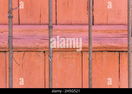 Stockholm, Sweden - April 15, 2021: Rusted sticks in symmetry on wooden background in red color Stock Photo