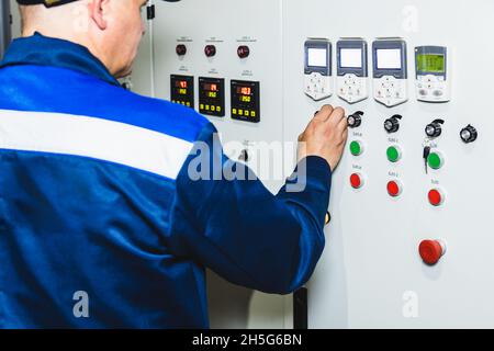 Hand pressing on green button of the machine in the factory Stock Photo