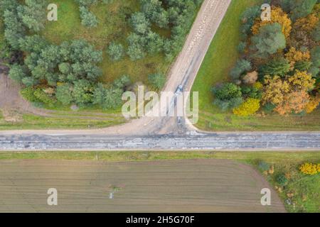 Aerial top down view of road interchange or intersection with single car driving Stock Photo
