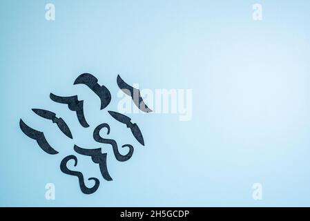 Mustaches as bird flock on light blue background upper view Stock Photo