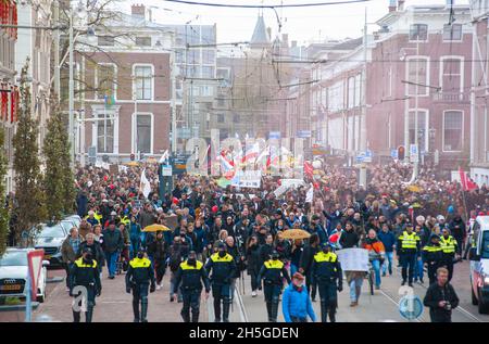Protesters march through The Hague city centre, with flags, banners, horns and loudspeakers denouncing new government Covid-19 measures.Police estimated 20,000 demonstrators took to the streets of The Hague in a demonstration march over the new anti-corona measures. The demonstrators oppose the use of vaccination certificates and QR codes, which they believe divide society instead of connecting it, some people also doubt the seriousness or validity of the pandemic, numerous publications were availed to re-enforce their beliefs. (Photo by Charles M. Vella/SOPA Images/Sipa USA) Stock Photo