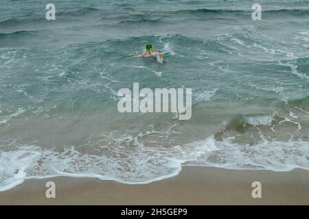 Aerial view of a Caucasian male with a frog head in the sea Stock Photo