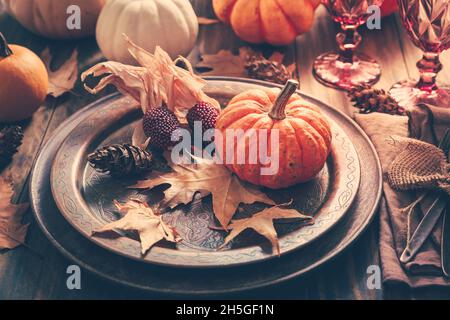 Place setting for Thanksgiving with pumpkins and autumn leaves in vintage style Stock Photo