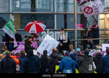 CARDIFF, WALES - NOVEMBER 09 2021: A protester with a sign reading 'NO TO MEDICAL APARTHEID' on the steps of the Welsh Parliament during a rally Stock Photo
