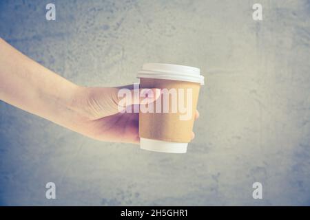 Hand holding disposable coffee cup Stock Photo