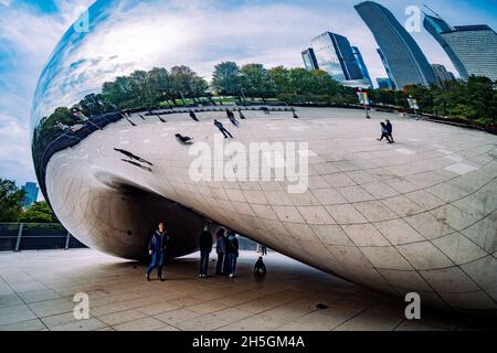 Only few people around Sir Anish Kapoor's sculpture Cloud Gate, nicknamed The Bean, in front of the skyline of Chicago, IL, USA Stock Photo