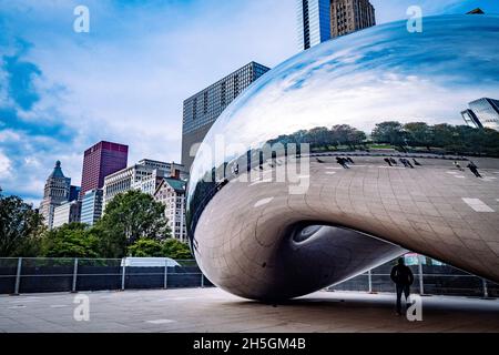 Only few people around Sir Anish Kapoor's sculpture Cloud Gate, nicknamed The Bean, in front of the skyline of Chicago, IL, USA Stock Photo