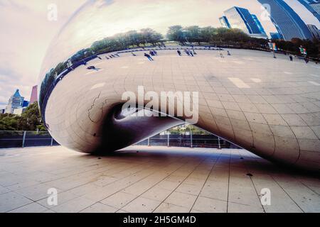 Only few people around Sir Anish Kapoor's sculpture Cloud Gate, nicknamed The Bean, in front of the skyline of Chicago, IL, USA Stock Photo