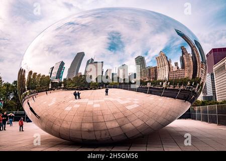 Only few people around Sir Anish Kapoor's sculpture Cloud Gate, nicknamed The Bean, in front of the skyline of Chicago, IL, USA Stock Photo