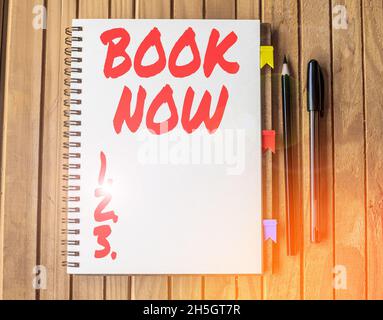 Text sign showing Book Now. Business showcase guaranteed to have place because you have already purchased it Blank Open Spiral Notebook With Diffrent Stock Photo