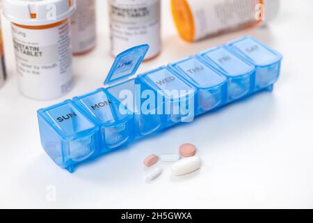 Blue color medicine organizer with prescription bottles isolated on white background Stock Photo