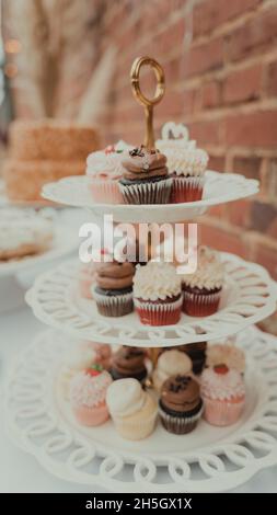 cupcakes arranged on a white metal three tier display Stock Photo
