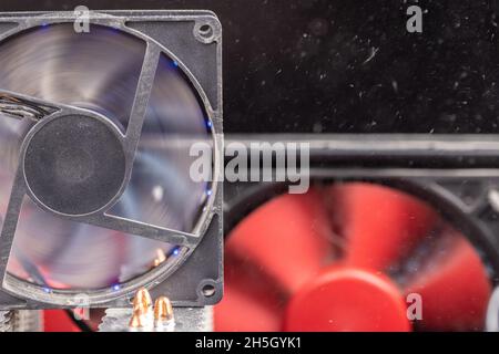 spinning 90 mm pc fan close-up with thick layer of dust and flying airborne dust particles Stock Photo