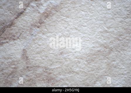 Roughly finished natural light marble with fine pale brown veins. Background, pattern, texture. Stock Photo