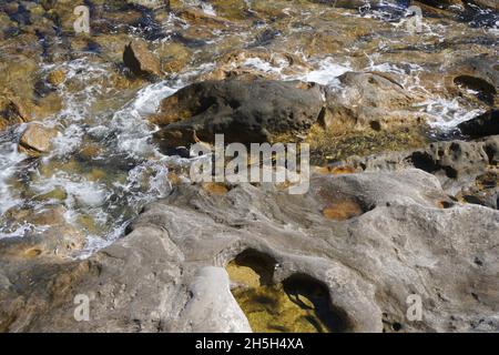 High Angle View of Water lapping Foreshore Rocks Stock Photo