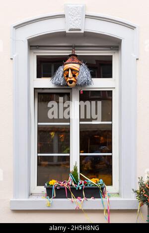 Basel, Switzerland - February 21. Carnival window decoration with a mask and colorful garlands Stock Photo