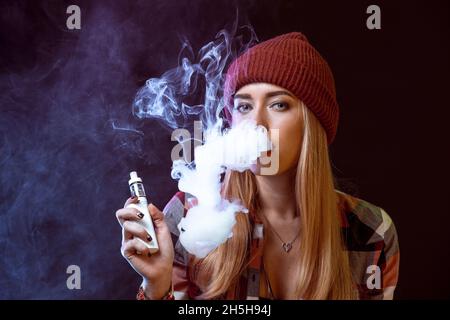 young woman smoking electronic cigarette Stock Photo