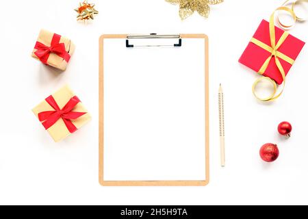 Festive Christmas background with white notepad sheet, present boxes and Christmas balls. Mockup, top view, flat lay Stock Photo