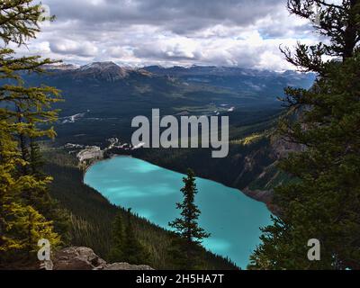 Stunning panoramic view of turquoise colored Lake Louise in Banff National Park, Alberta, Canada in the Rocky Mountains on cloudy day in autumn season. Stock Photo